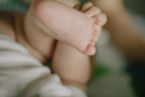 Close Up Of A Toddler Holding Their Foot Photo