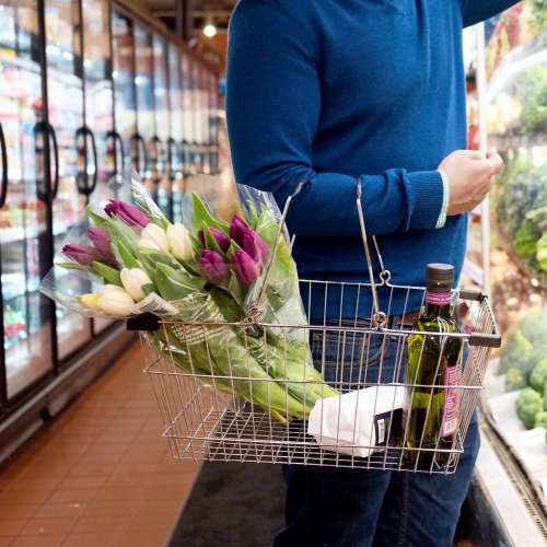 Person Holds A Silver Shopping Basket Carrying Tulips Photo