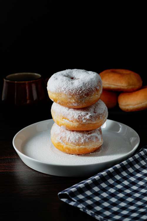 Stack Of Doughnuts With White Powered Tops On A Plate Photo