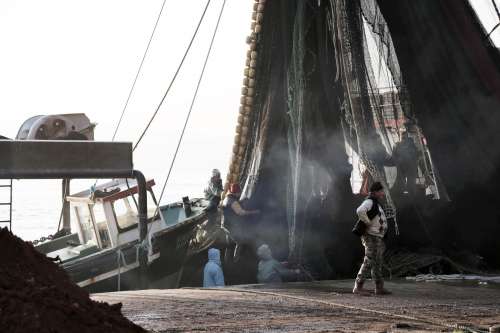 People Working With Nets And Mast Of A Boat Photo