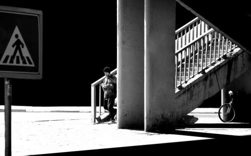 A Person Walking Down A City Stairwell In Monochrome Photo
