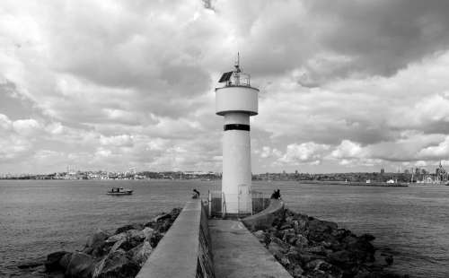 Black And White Lighthouse Overlooking Calm Water Photo