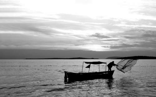Black And White Photo A Person Throwing A Fishing Net Photo
