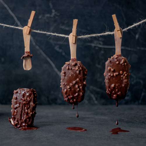 Three Ice Cream Bars Hang From Clothespins Upside Down Photo