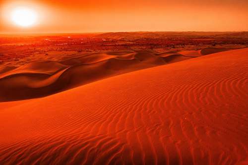 Orange Sunset Over Wavy Sand Dune Landscape Photo