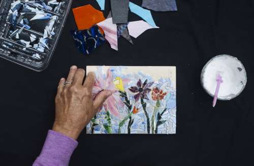 A Person Adding Glass To Their Mosaic Of Flowers Photo