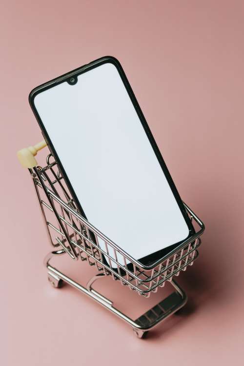Black Cell Phone In A Small Silver Shopping Cart Photo