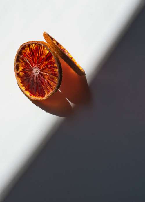 Dried Orange Slices Cast A Orange Shadow On White Photo