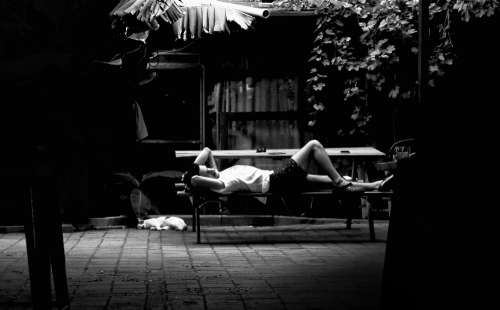 Person Laying On Picnic Table In Black And White Photo