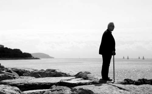 Monochrome Man Standing Alone Looking Beyond The Shore Photo