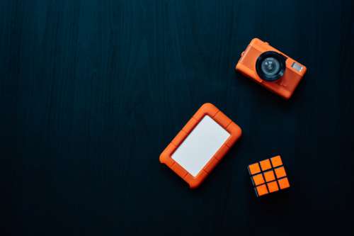 Flatlay Of A Camera Rubiks Cube And Hard Drive Photo