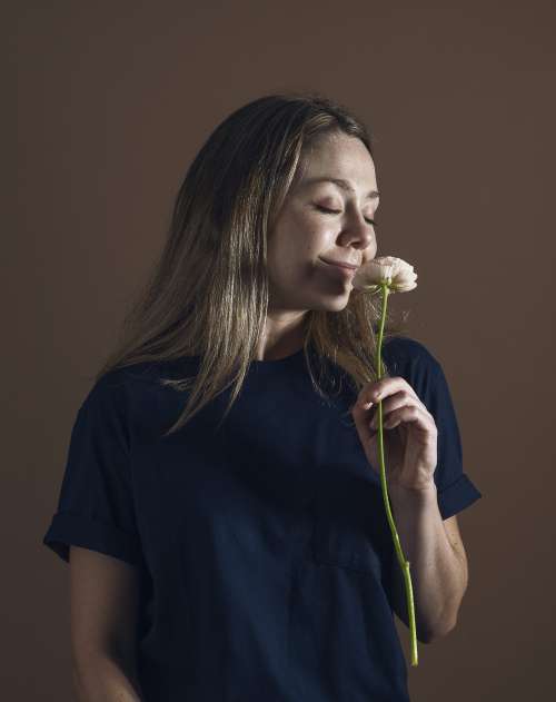 Woman Holds And Smells A Single Ranunculus Flower Photo