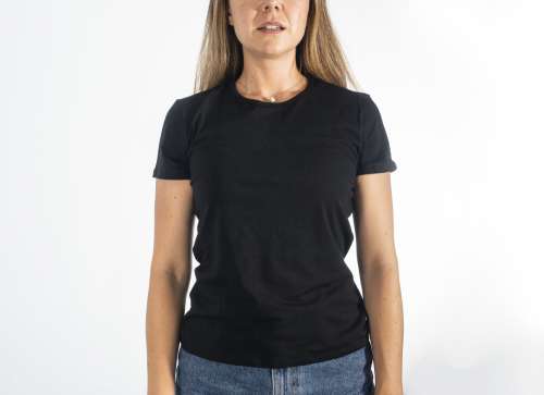 Person In A Blank Black Shirt Stands Against White Background Photo