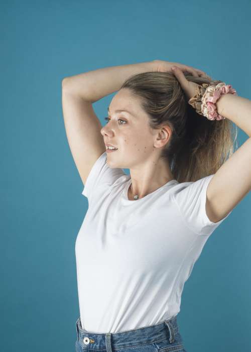 Woman In A White Shirt Puts Her Hair Up With Scrunchies Photo