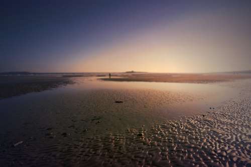 Beach With Shallow Water With Person In The Distance Photo