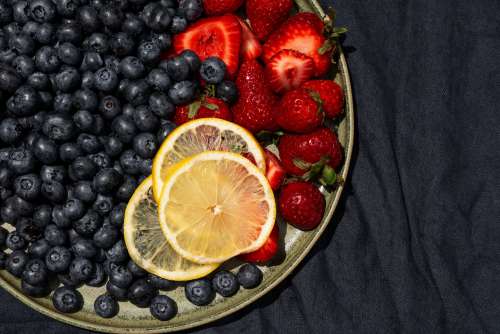 Summer Fruits On A Green Plate With A Blue Tablecloth Photo