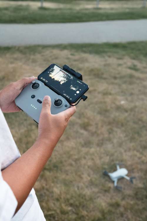 Hands Holding The Controls Of A Drone Photo