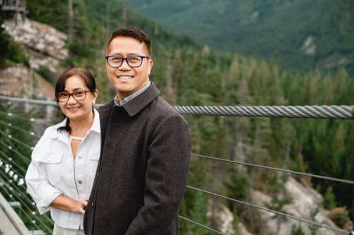 Two People Smiling While Surrounded By Dense Forest Photo
