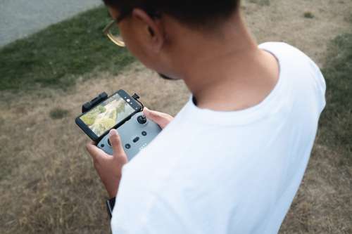 Looking Over The Shoulder Of Someone Holding A Drone Photo