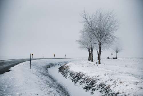 Snowy Landscape Of A Winter Road Curving Through Trees Photo
