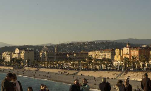 Beach And Overlooking City With People Exploring Photo