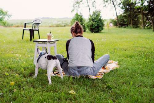 Female having a coffee outdoors with a frenchie