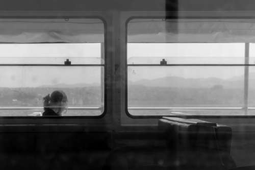 Black And White Photo Of A Person Sitting In A Window Photo