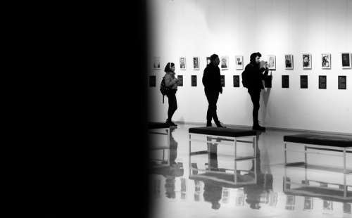People At An Art Gallery Facing The Work Photo