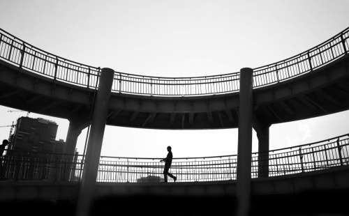 Black And White Photo Of A Person And Walkway Silhouetted Photo