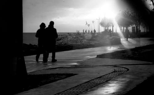 Black And White Photo Of People On A Shoreside Path Photo