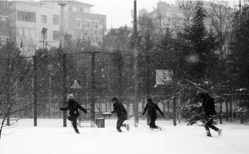 Black And White Photo Of People Running As It Snows Photo