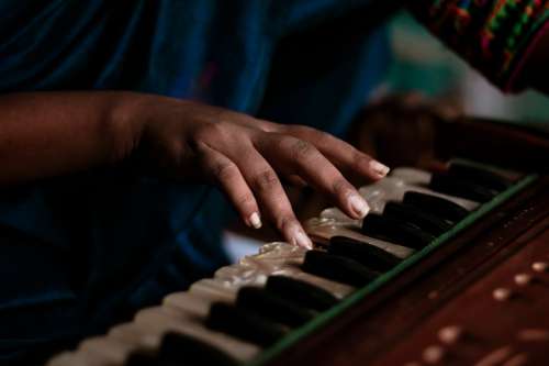 Hand Placed On The Iridescent Keys Of A Small Piano Photo
