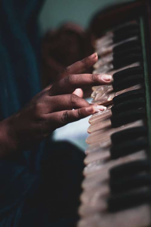 Hand Playing On White Iridescent Piano Keys Photo