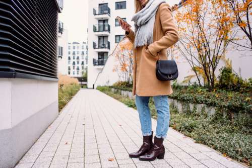 Female holding her phone on an autumn day