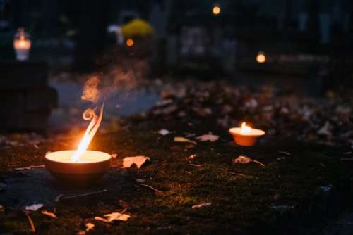 Burning candles on an old grave at the cemetery
