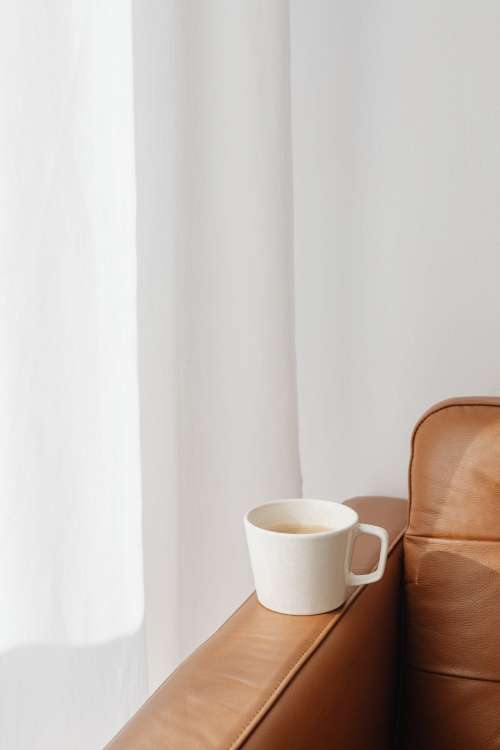 A cup of coffee and a leather sofa