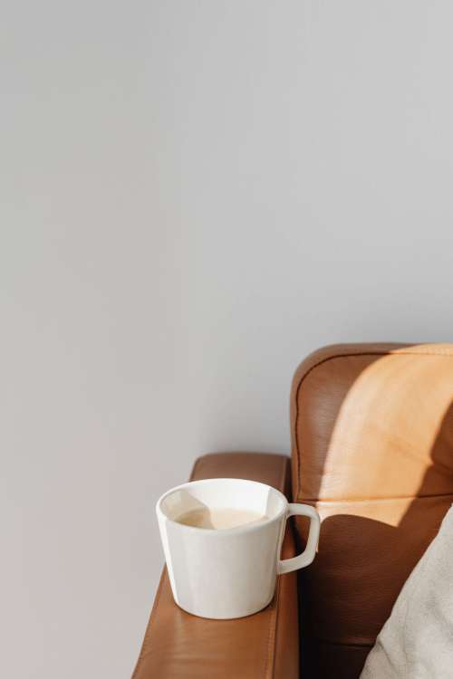 A cup of coffee and a leather sofa