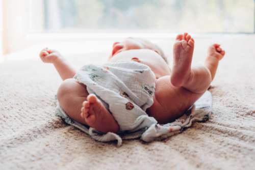 Newborn baby lying down on the mattress 2