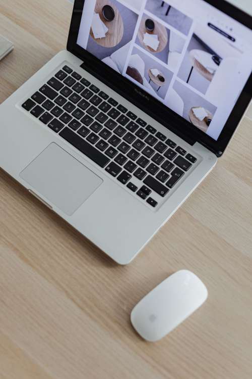 Home office desk with laptop by a large window