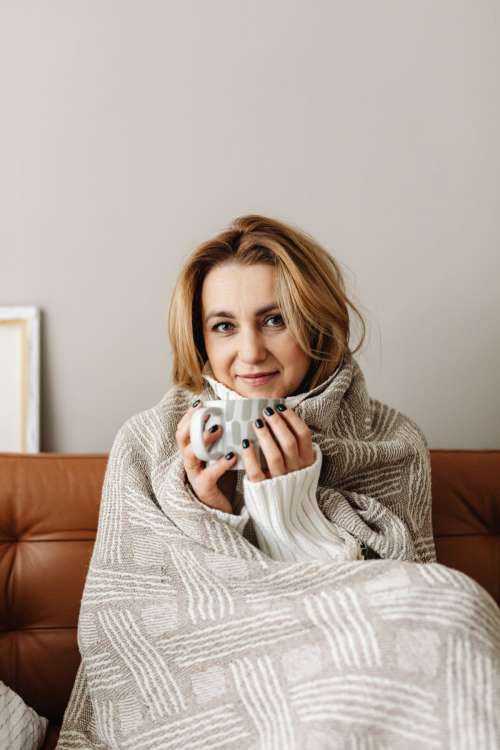 Cocooning - isolating yourself - stay at home - woman under blanket