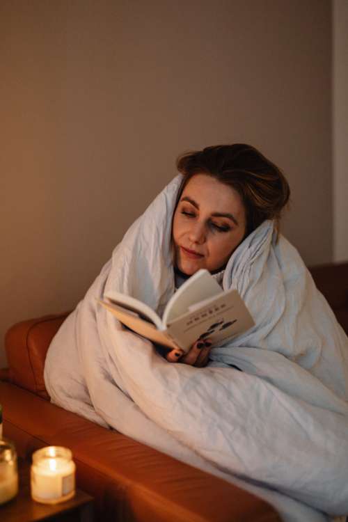 Cocooning - isolating yourself - stay at home - woman under blanket