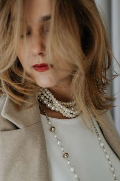 Woman is wearing pearls and jewelry