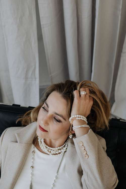 Woman is wearing pearls and jewelry