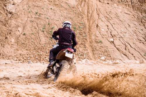 Motor biker riding through a sand quarry 2