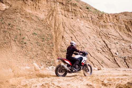 Motor biker riding through a sand quarry