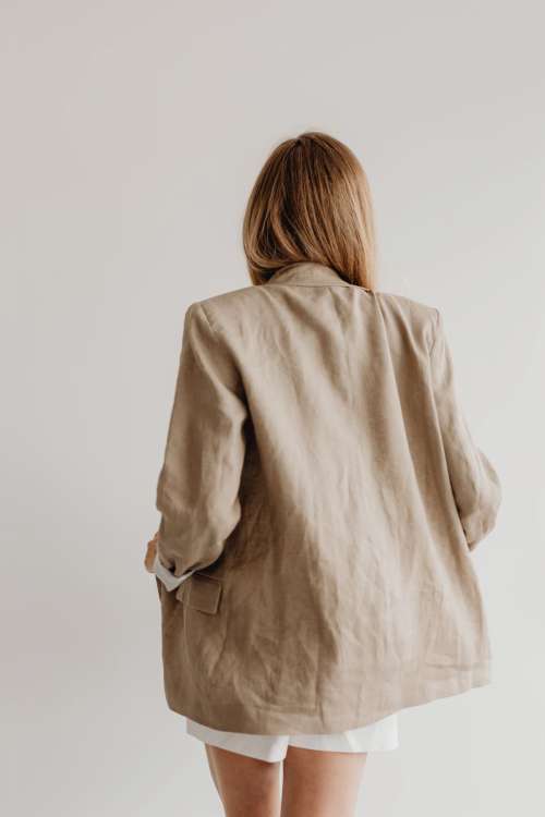 Woman wearing white elegant shorts and linen oversize jacket