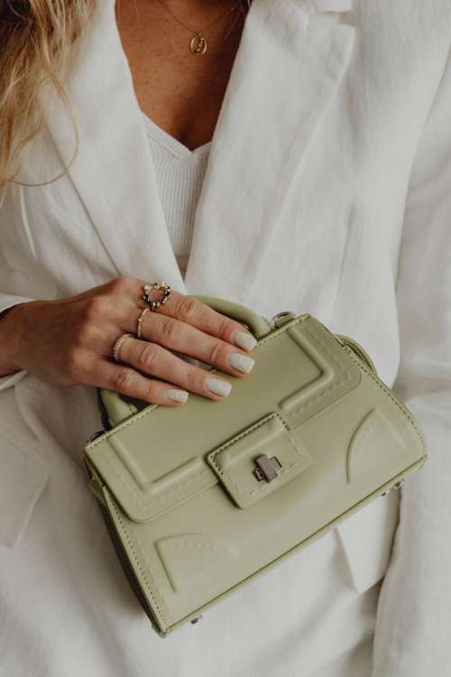 Anonymous female in trendy outfit with bag