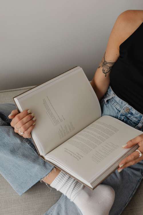 Woman in light-colored jeans with books