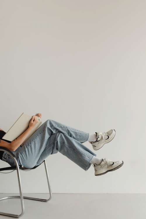 Woman in light-colored jeans with books