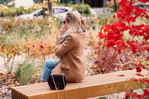 Female sitting on a bench and talking on the phone